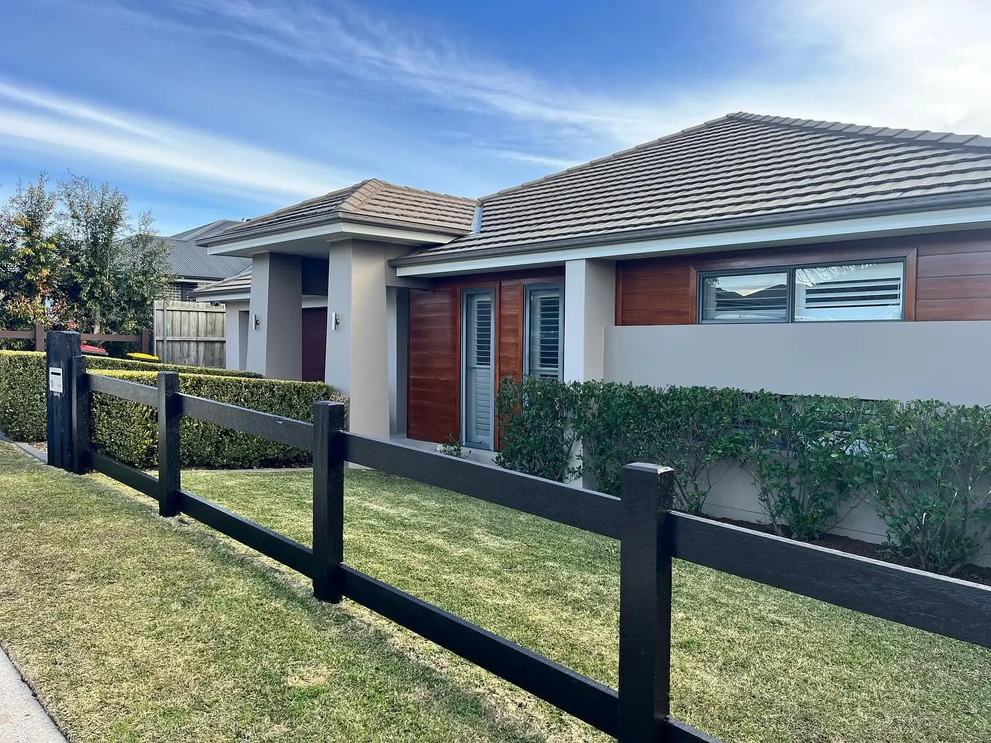 House exterior with a new black timber fence